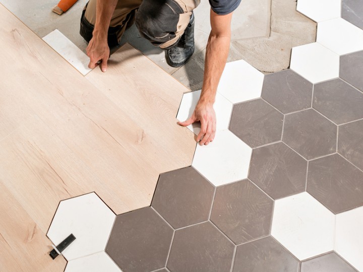 Male Worker Installing New Wooden Laminate Flooring. The Combina